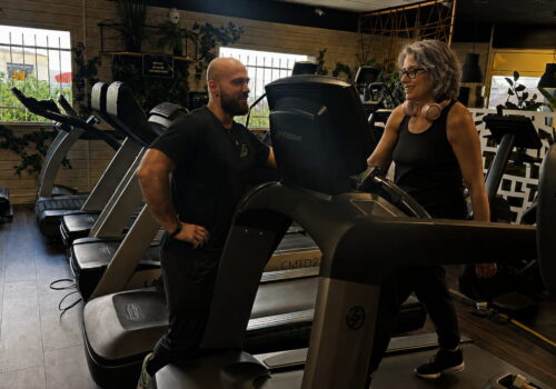Femme de 55 ans en séance de cardio sur tapis Life Fitness accompagnée par son coach E3S — programme reprise du sport FitGood Nantes